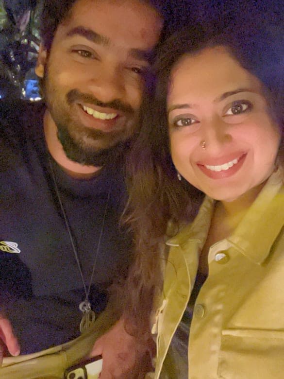 Sneha and Chan smiling together in a selfie at night