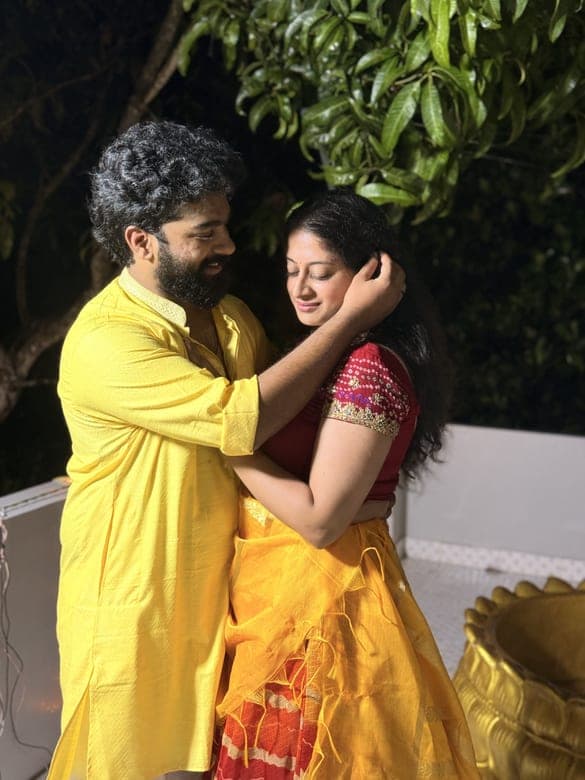 Chan and Sneha embracing in festive yellow and red outfits